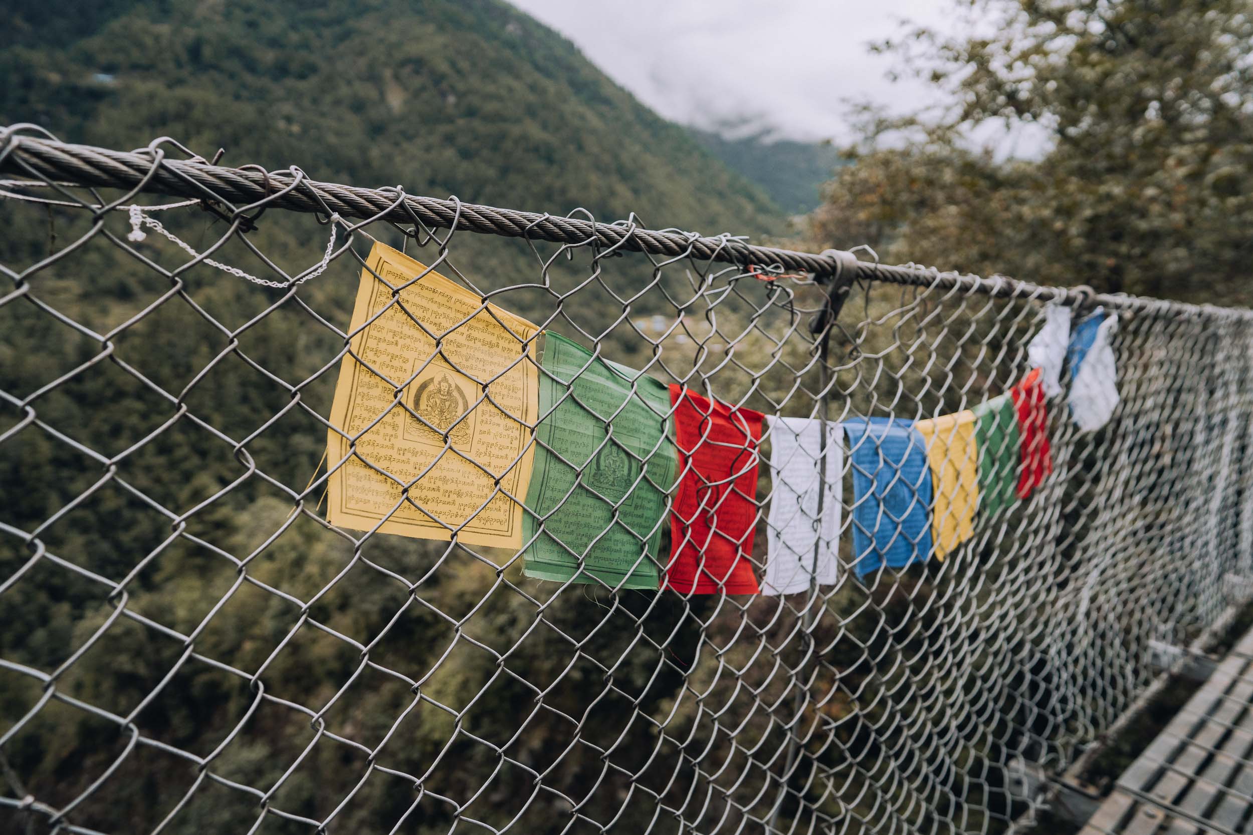 Nepalese wind horses on the side of a footbridge